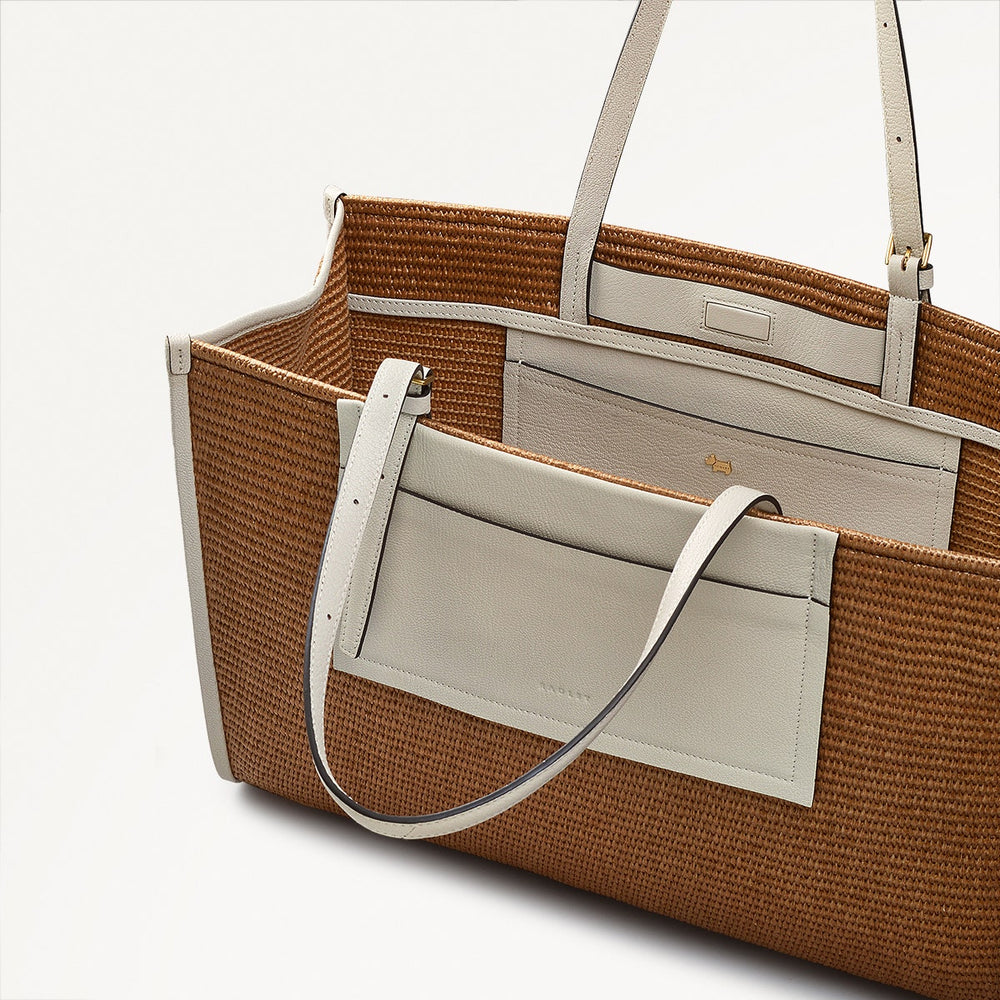 Brown woven tote bag with beige handle and trim on a white background