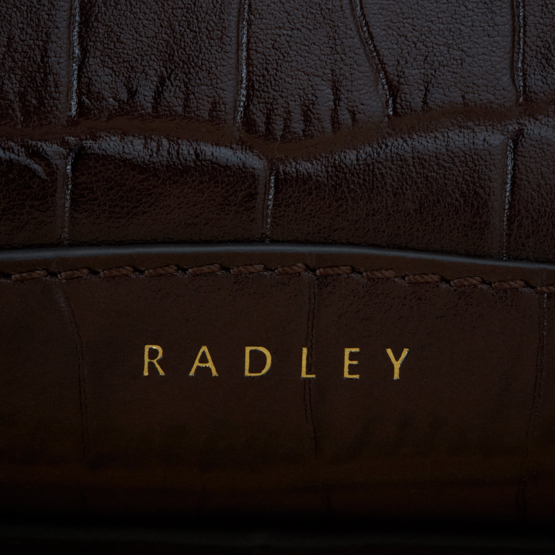 Close-up of brown leather with 'RADLEY' branding.