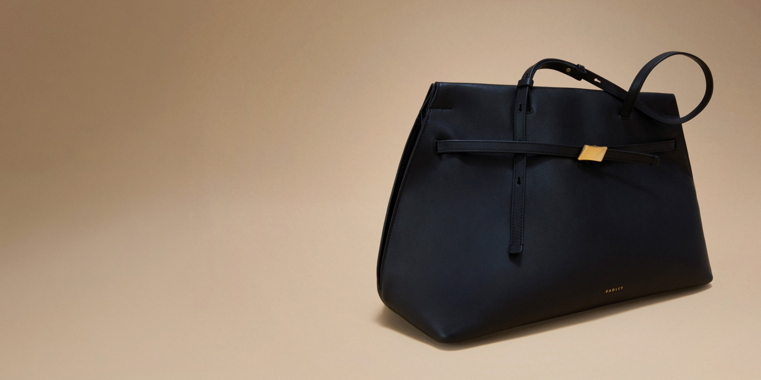 Black handbag on a beige background